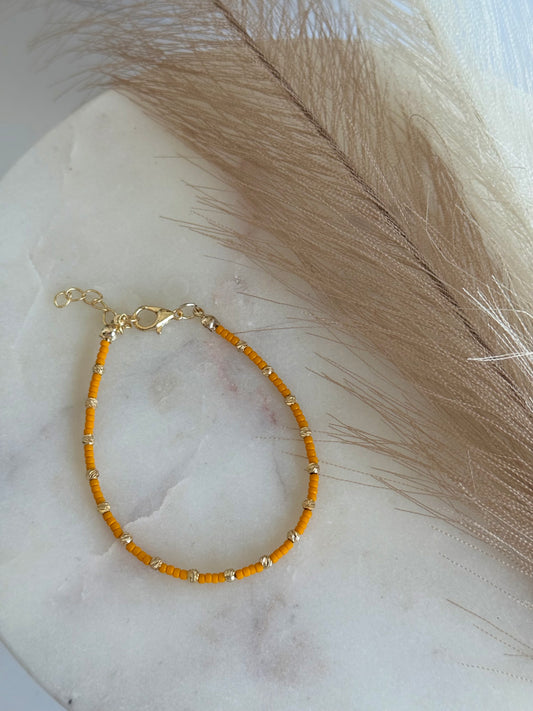 Perlenarmband mit orangen und goldfarbenen Mini-Perlen