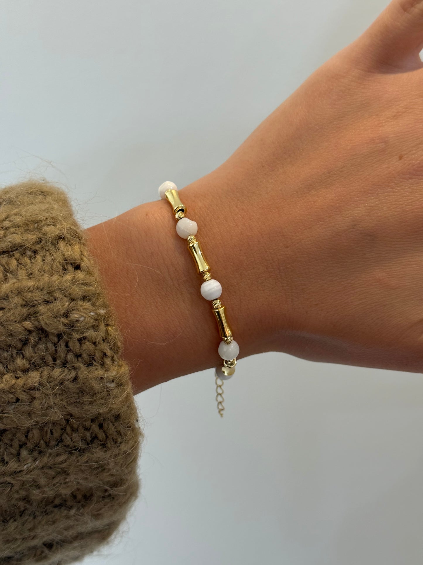 Armband mit weißen Steinperlen und goldfarbenen Akzenten