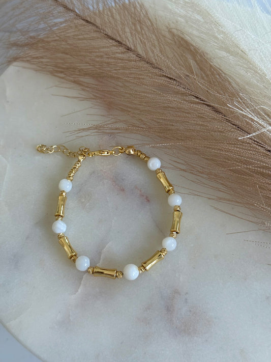 Armband mit weißen Steinperlen und goldfarbenen Akzenten