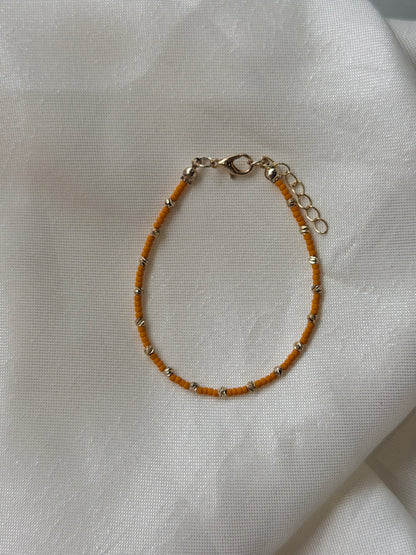 Perlenarmband mit orangen und goldfarbenen Mini-Perlen