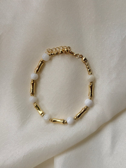 Armband mit weißen Steinperlen und goldfarbenen Akzenten
