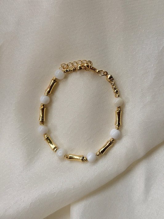 Armband mit weißen Steinperlen und goldfarbenen Akzenten