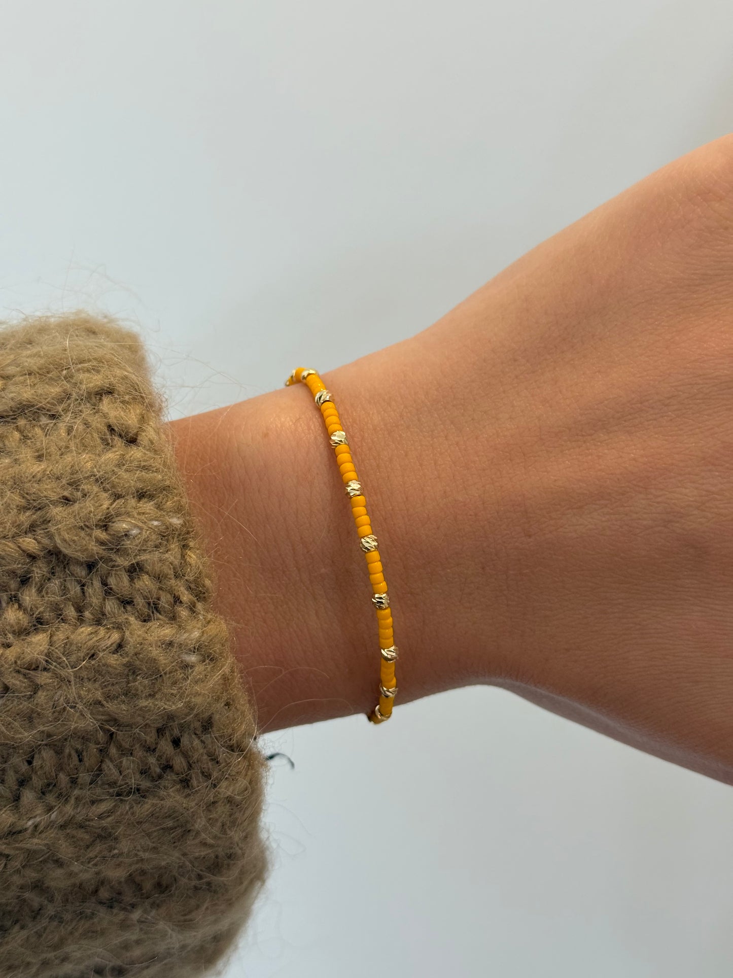 Perlenarmband mit orangen und goldfarbenen Mini-Perlen